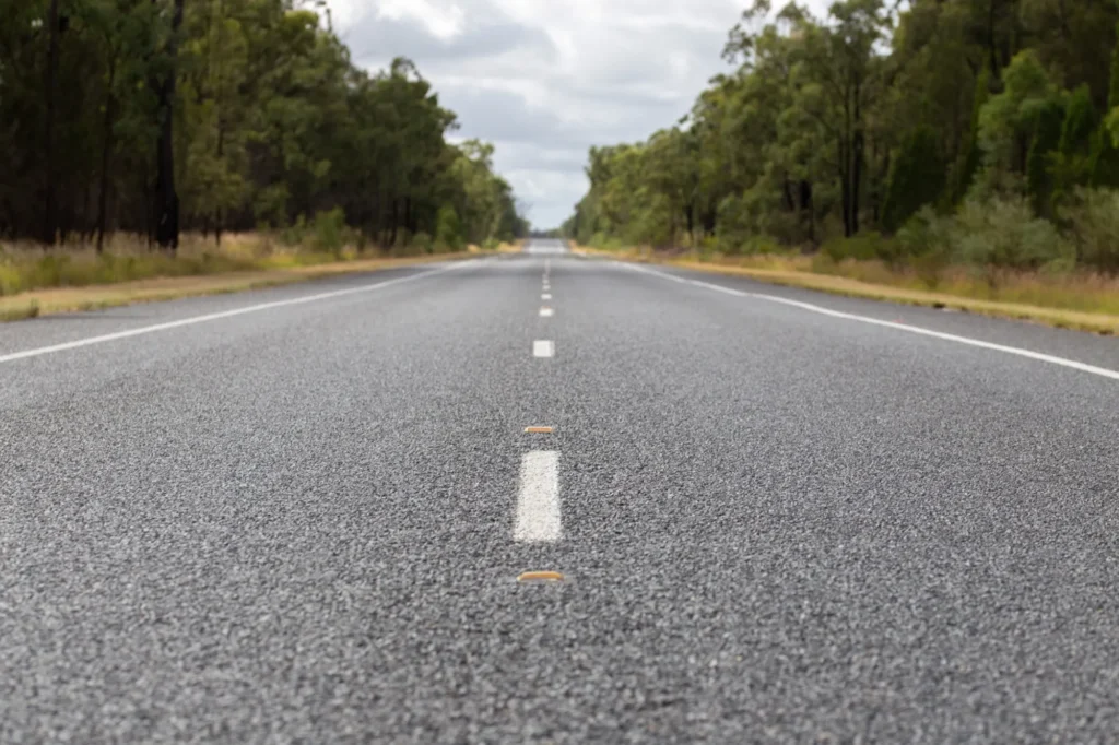 Open road stretching to the horizon through Australian bushland